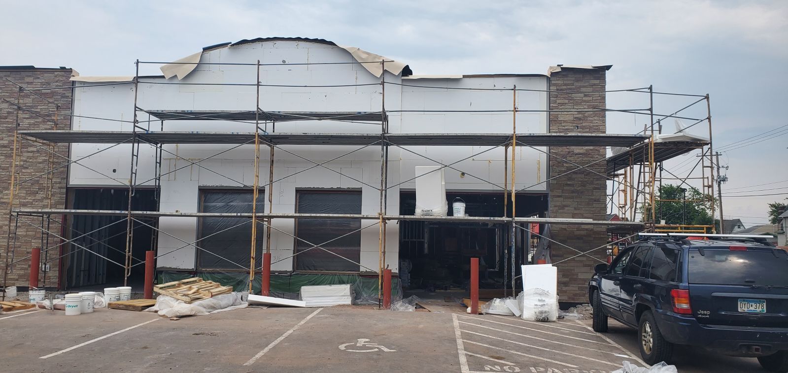 A building under construction with brick walls and scaffolding.