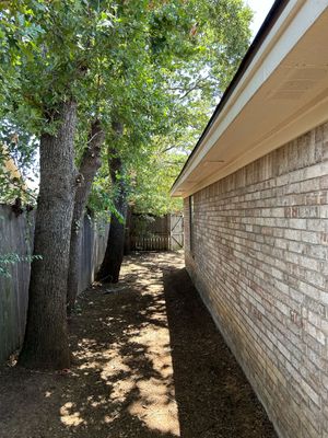 A brick wall with trees on the side of it.