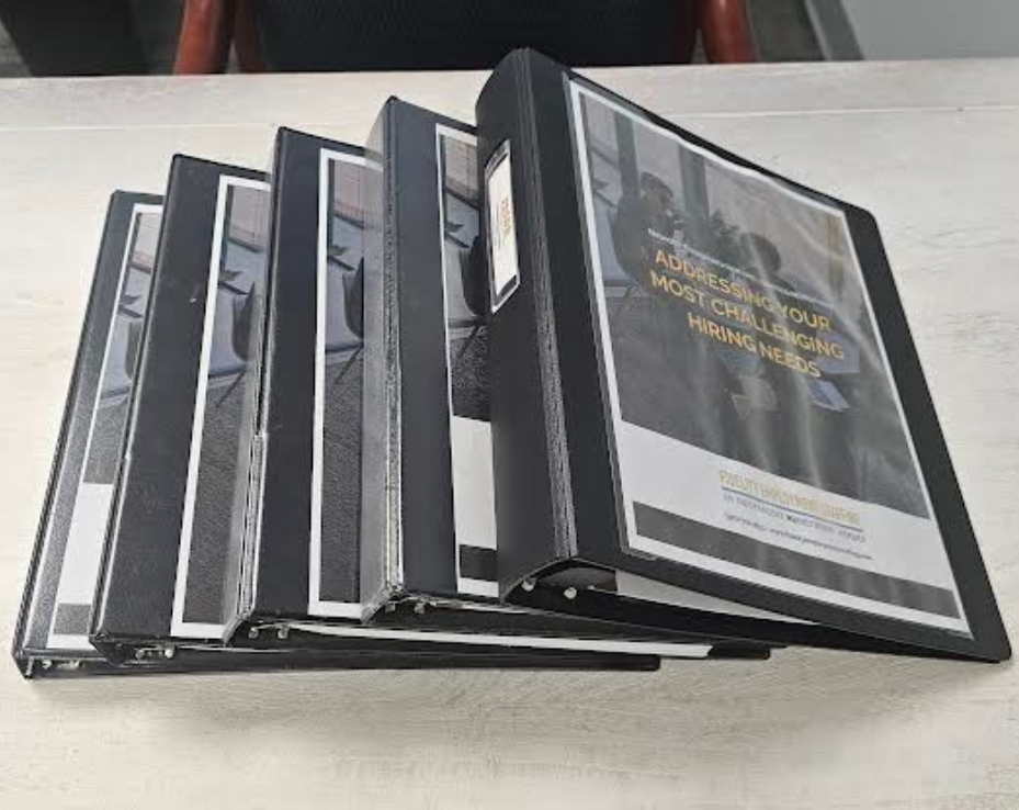 Wall-mounted document display with several black frames holding papers, angled down for easy viewing.