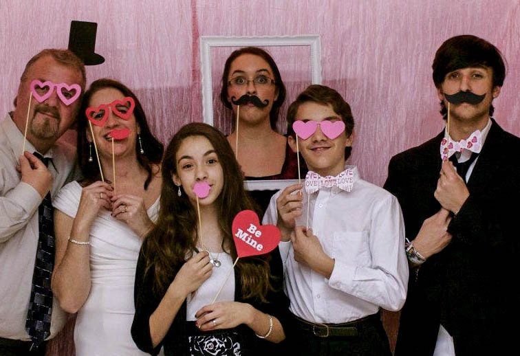 A bride and groom are kissing in a photo booth.