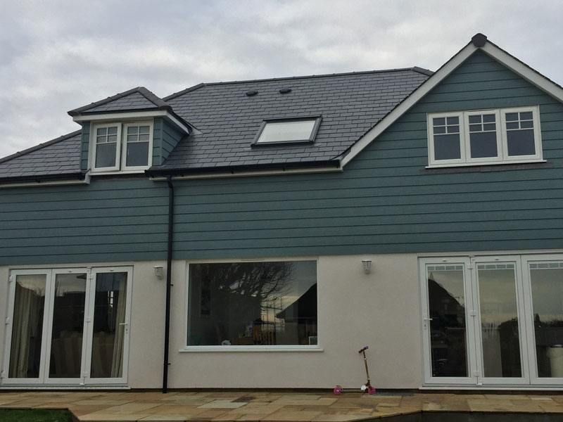 Namas su šiferiniu stogu, o priešais – paspirtukas