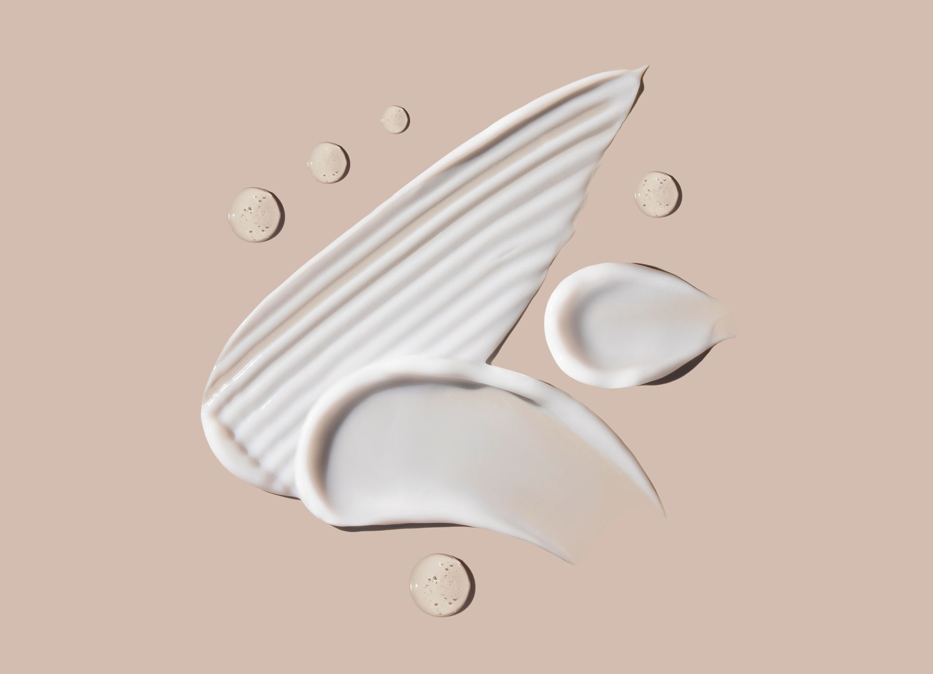 Eine Nahaufnahme eines weißen Crememusters auf beigem Hintergrund.