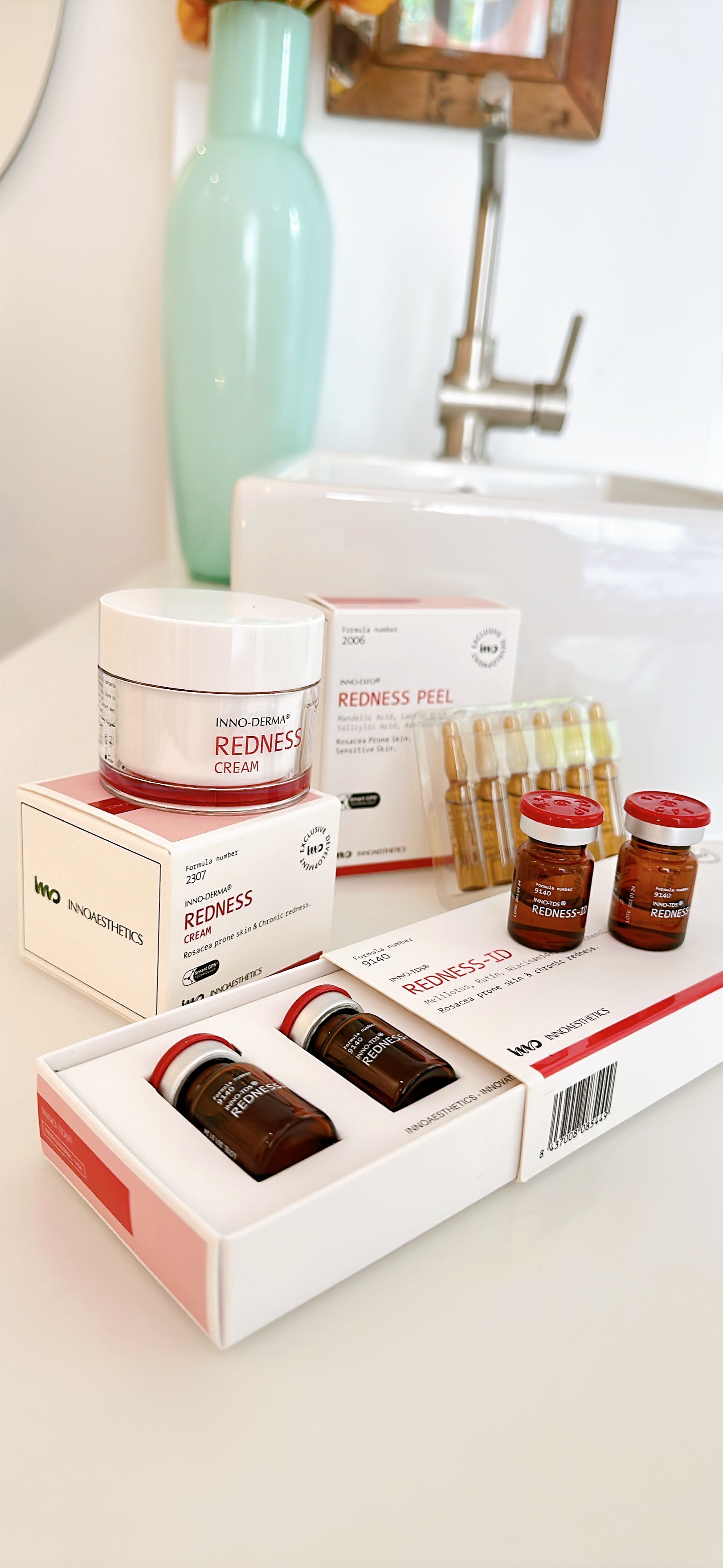 Auf einer Ablage neben einem Waschbecken steht ein Tablett mit Kosmetikartikeln.