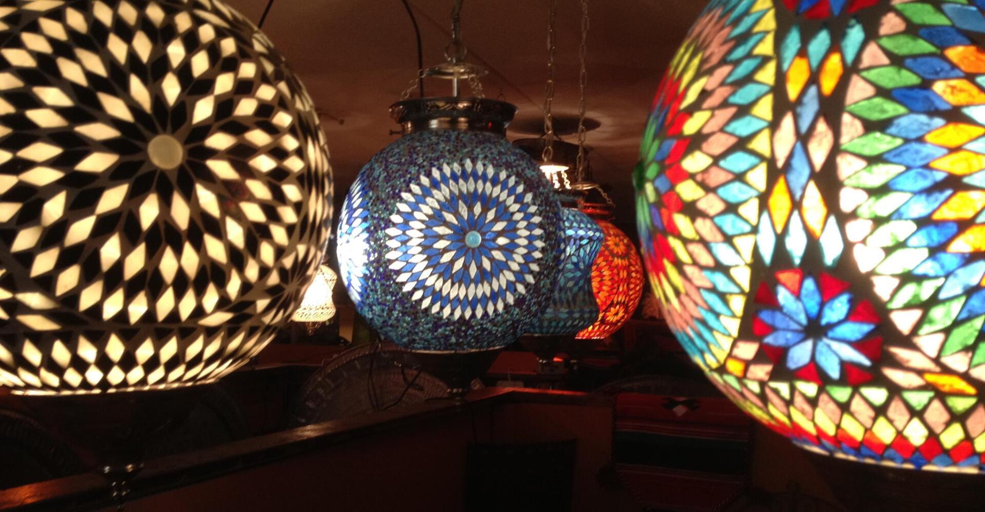 Een groep kleurrijke lampen die aan het plafond hangen.