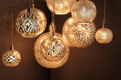 Een groep hangende lampen met Arabische letters erop