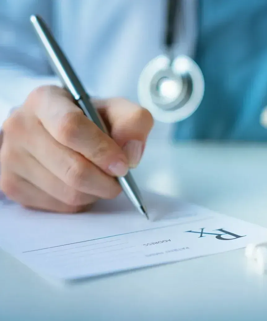 A woman in a white lab coat is smiling for the camera.