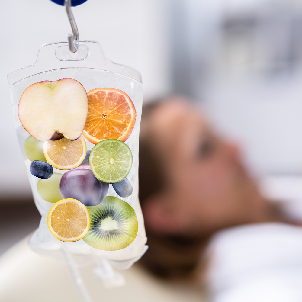 IV bag filled with fruit hanging above a person in a hospital bed.