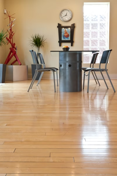 Hardwood floor in a room with a table, chairs, decor, and a window.
