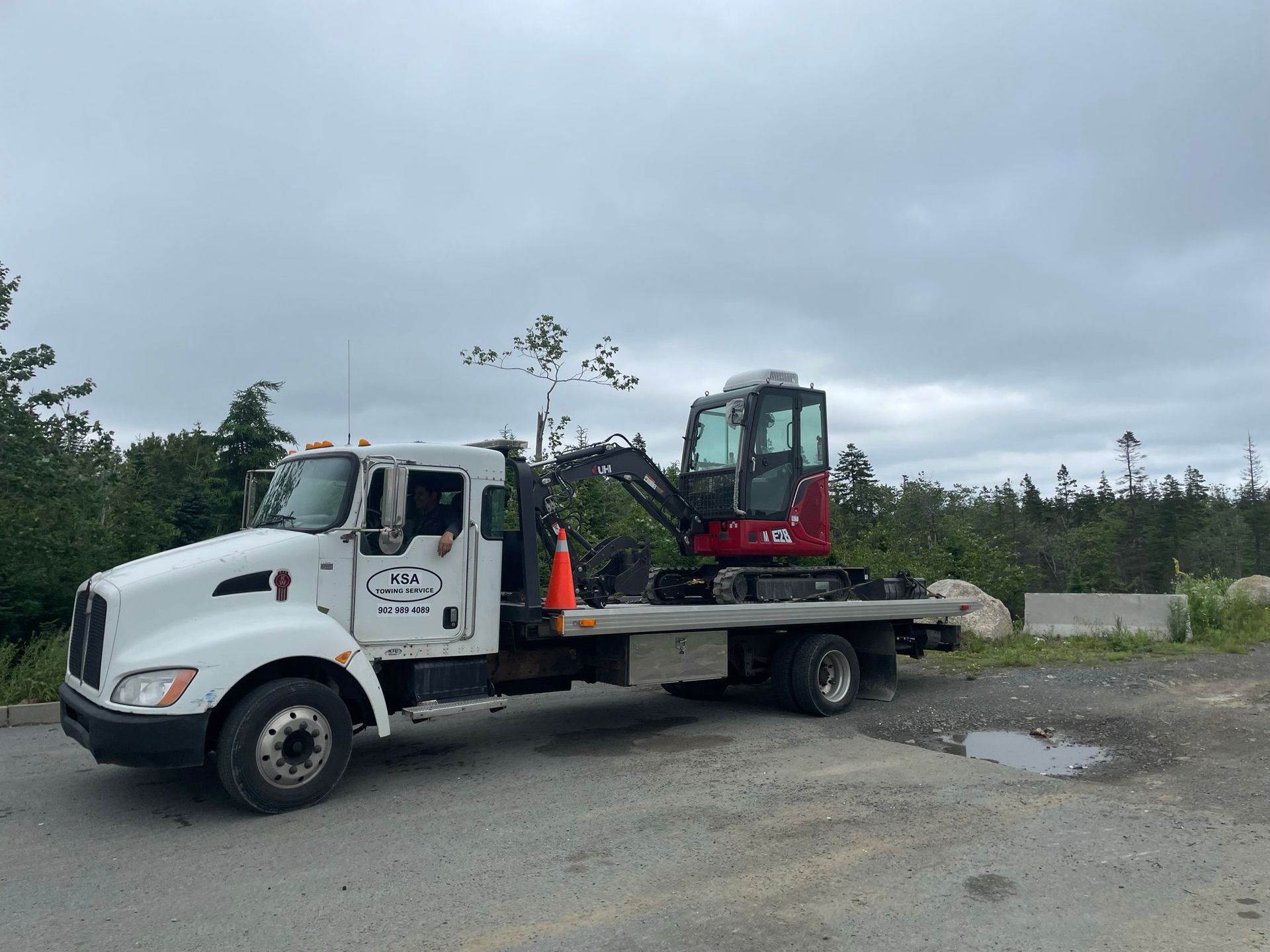 A tow truck towing an excavator