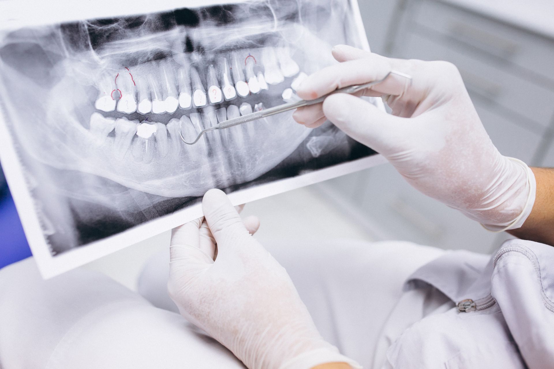 A dentist is looking at an x-ray of a person 's teeth.