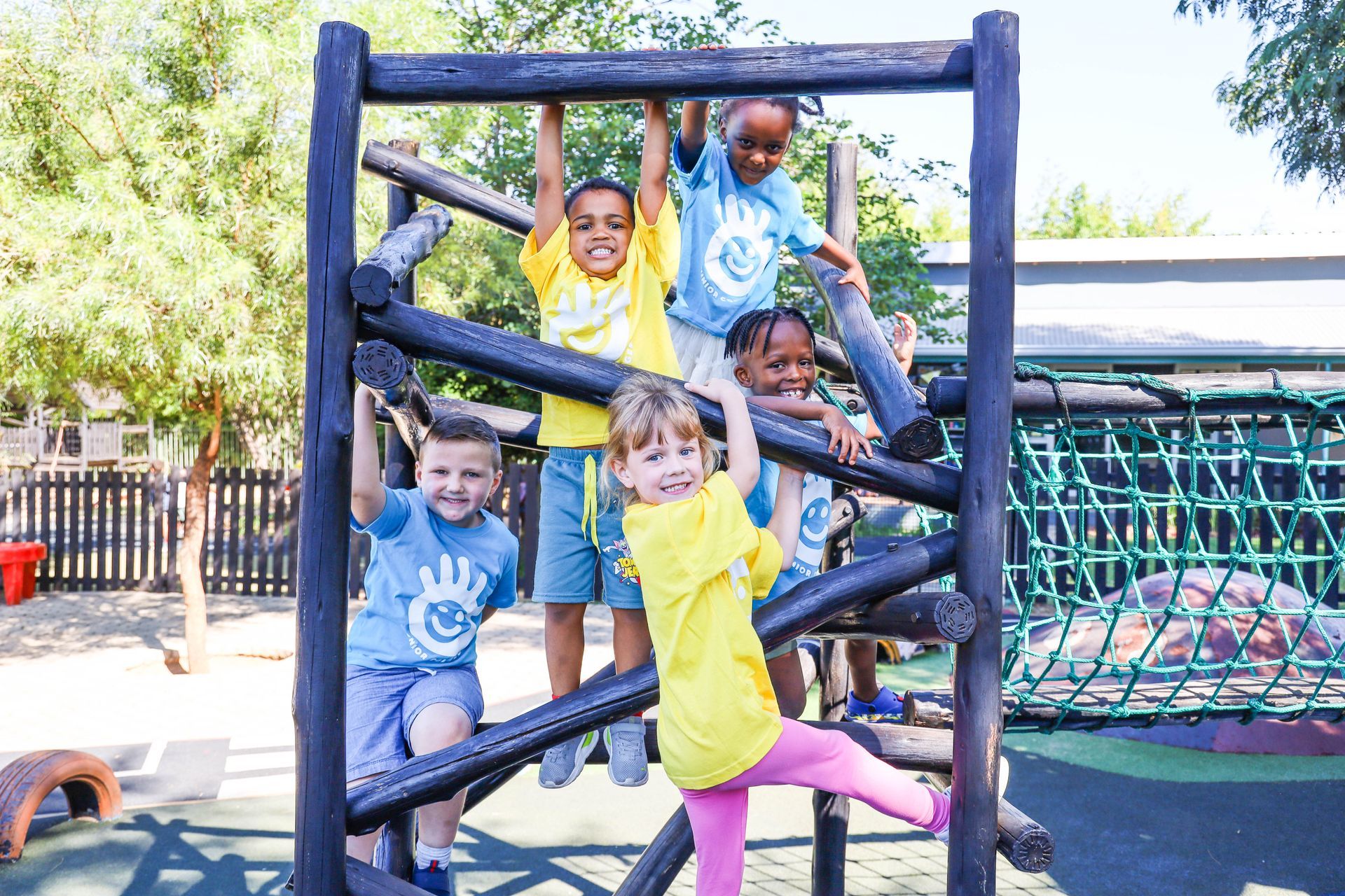 A young boy is wearing a yellow vest and holding a bottle.