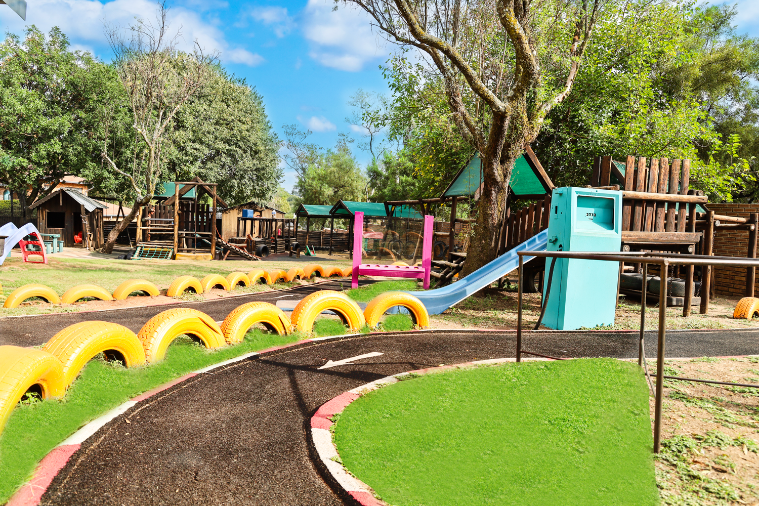 A playground with a track made out of tires and a slide.