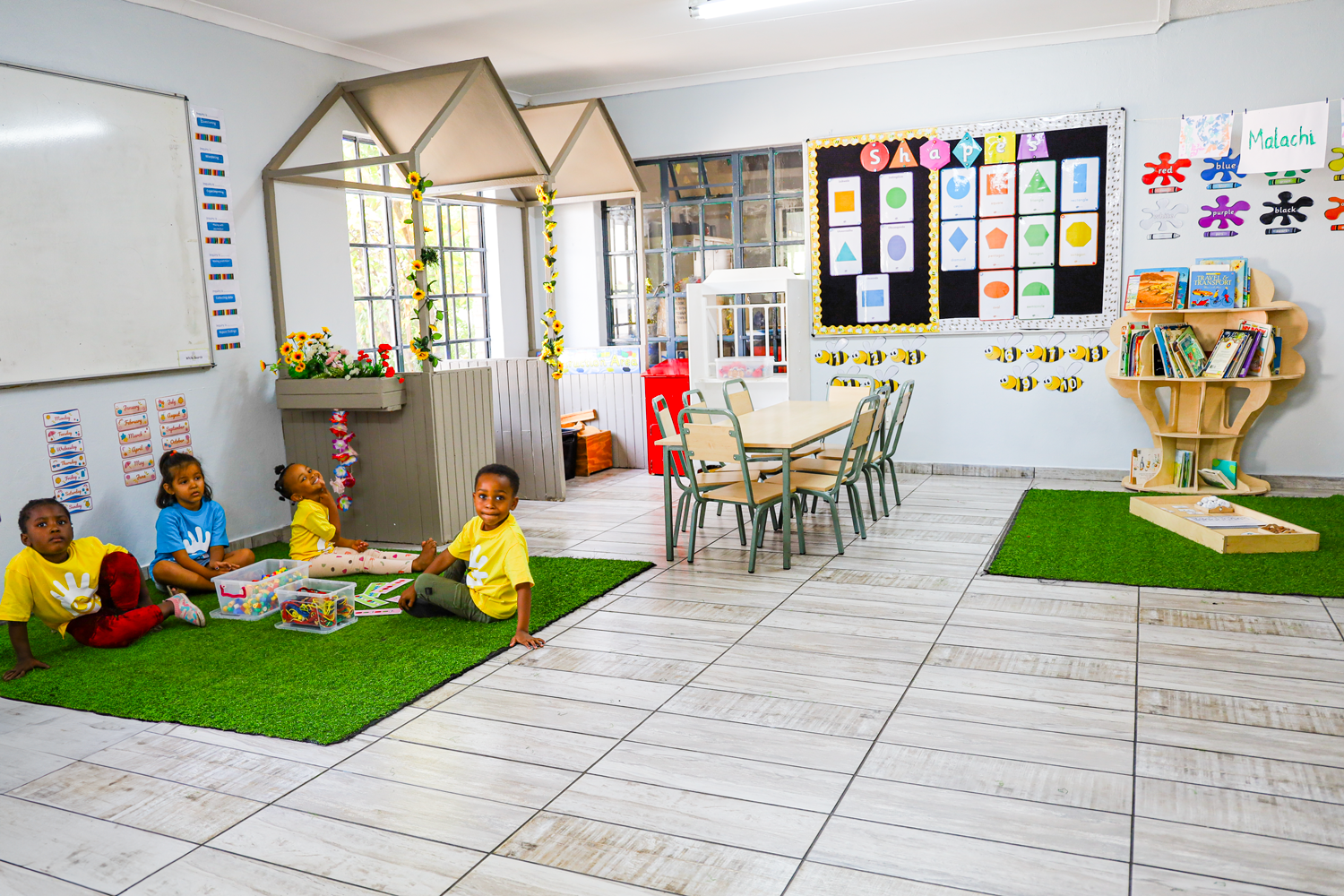 A group of children are sitting on the floor in a classroom.