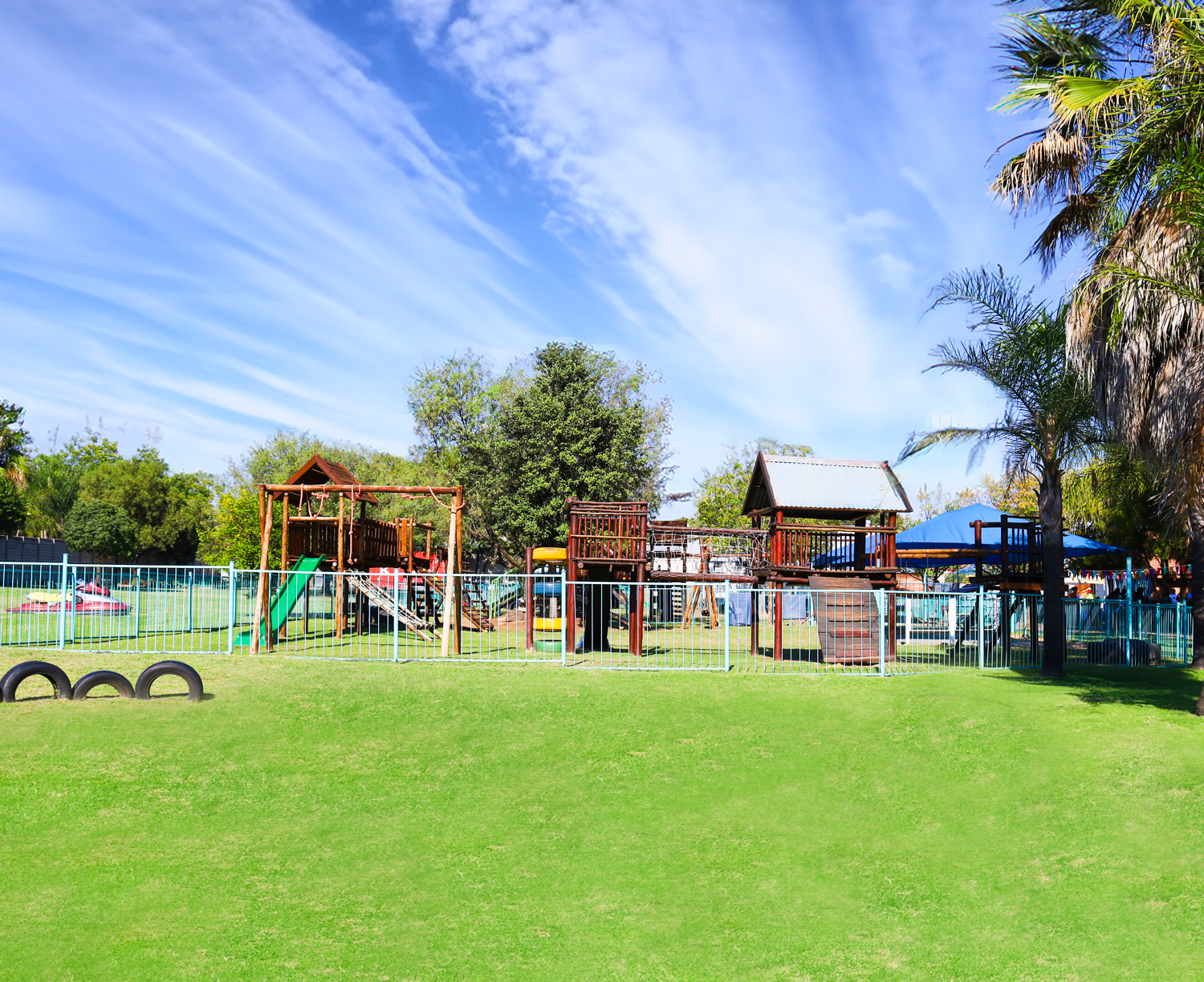 A playground in a park with a blue sky in the background