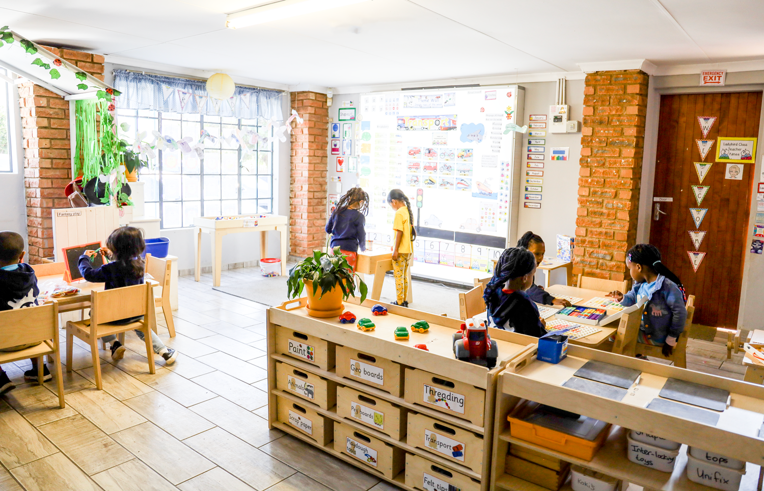 A group of children are playing with toys in a classroom.
