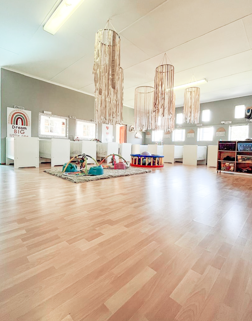 A large room with wooden floors and lots of windows