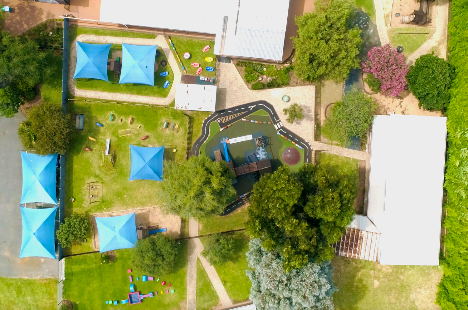 An aerial view of a swimming pool surrounded by trees and buildings.