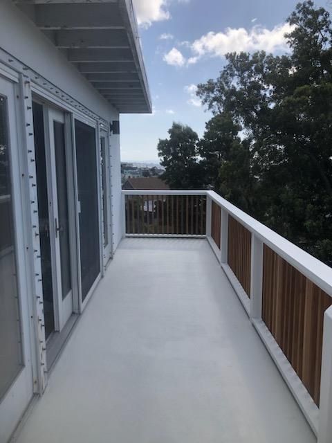 A balcony with sliding glass doors and a wooden railing