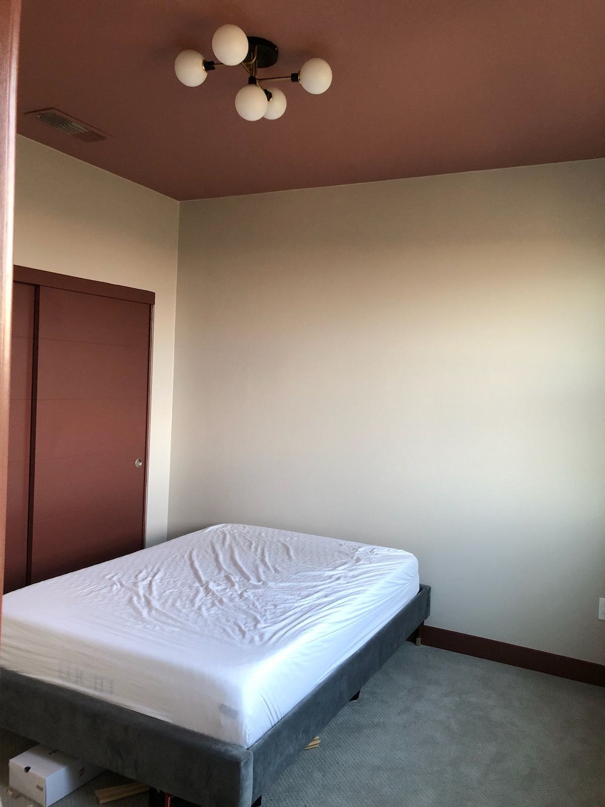 A bedroom with a bed and a chandelier on the ceiling.