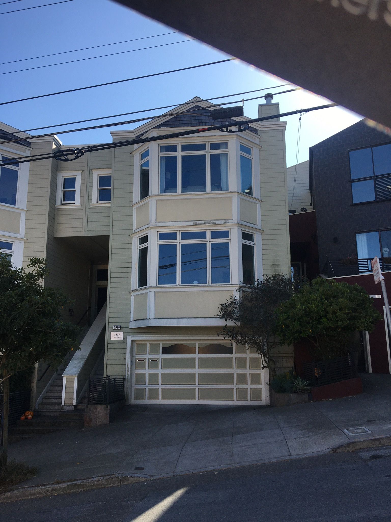 A large house with a white garage door and stairs