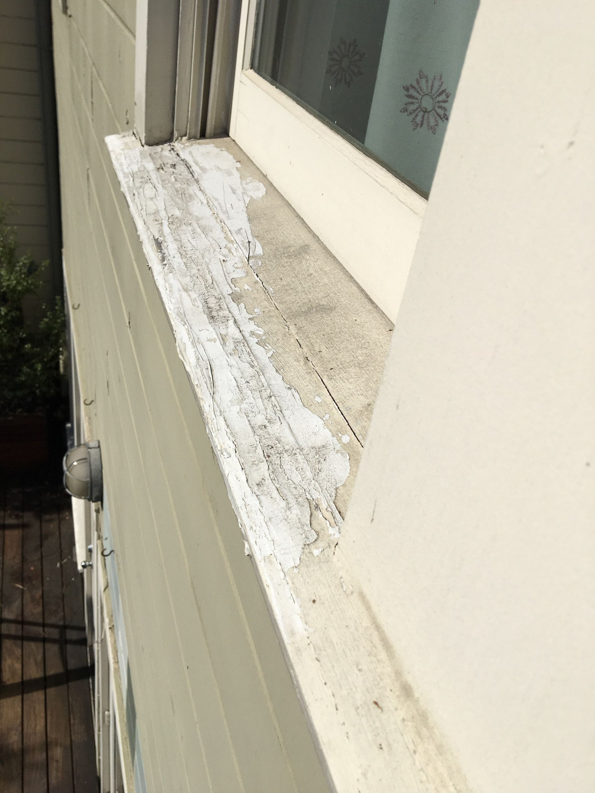 A close up of a window sill on a white building.