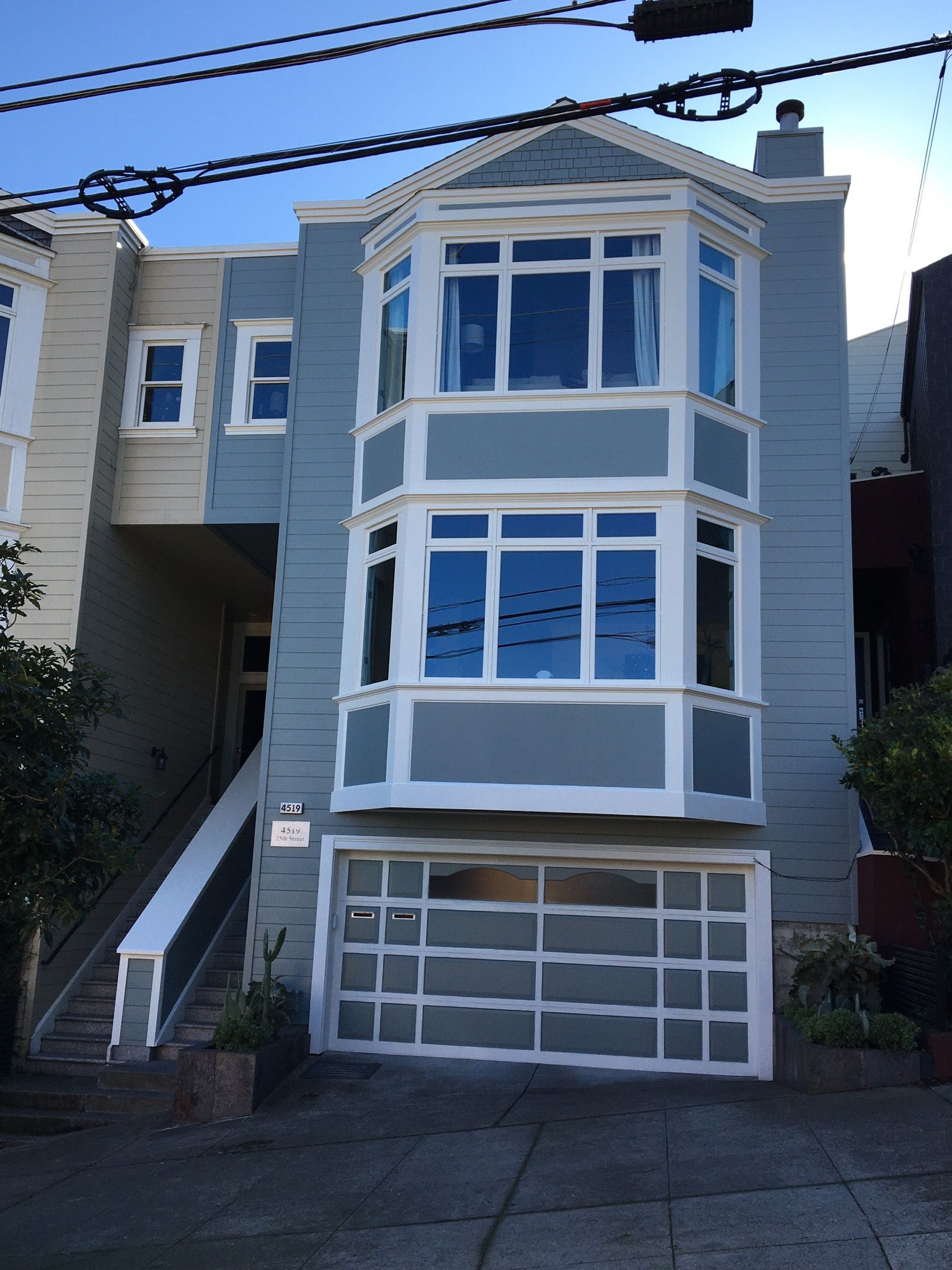 A blue and white house with a garage and stairs