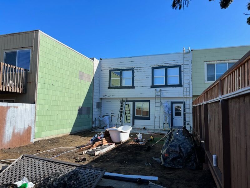 The backyard of a house that is being painted white