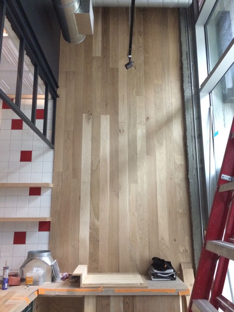 A room with a wooden floor and a ladder in it