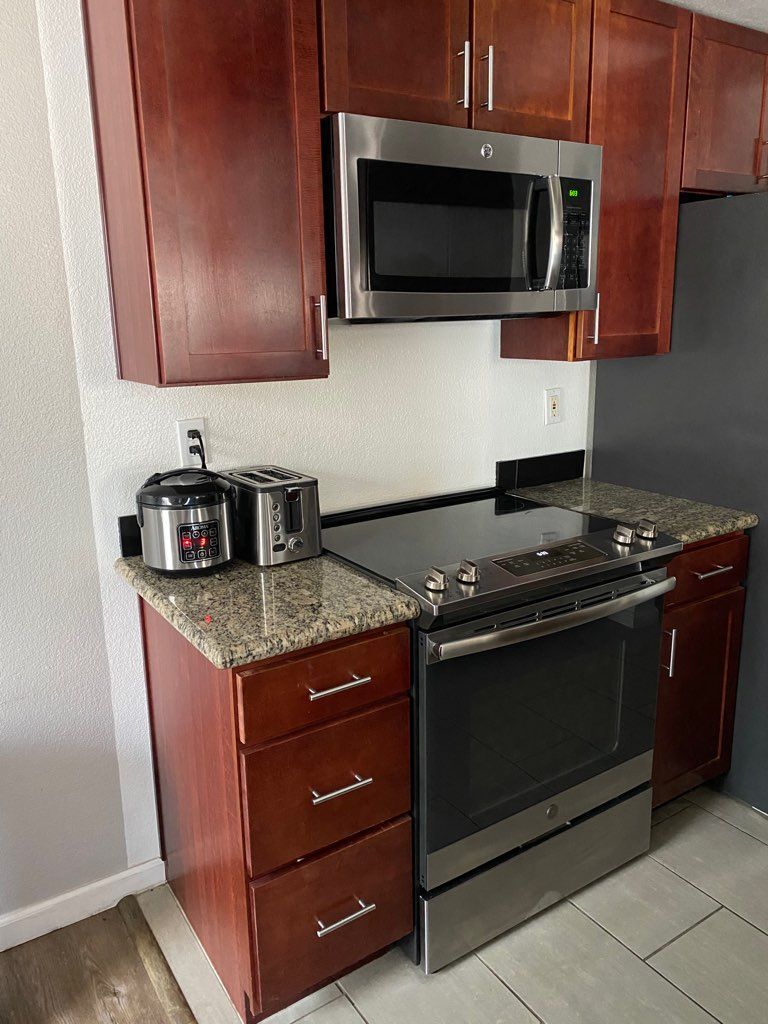 A kitchen with stainless steel appliances and wooden cabinets.