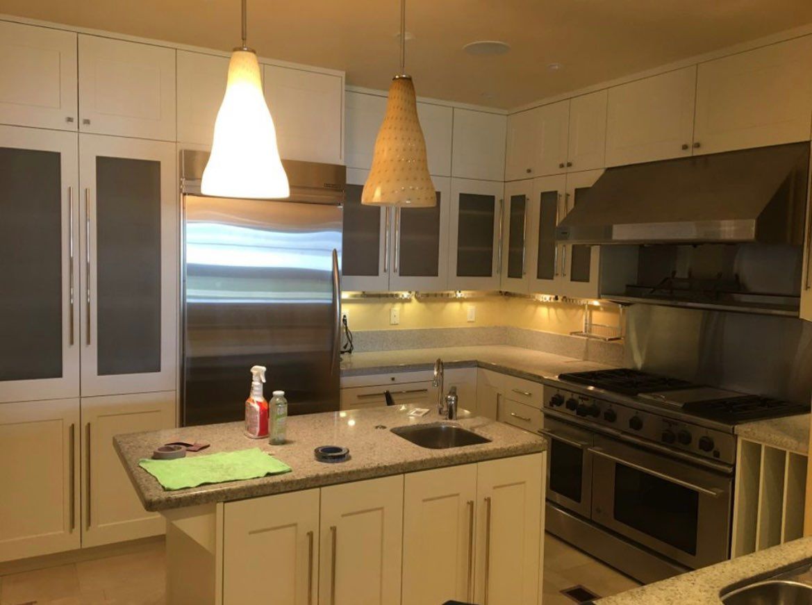 A kitchen with white cabinets and stainless steel appliances