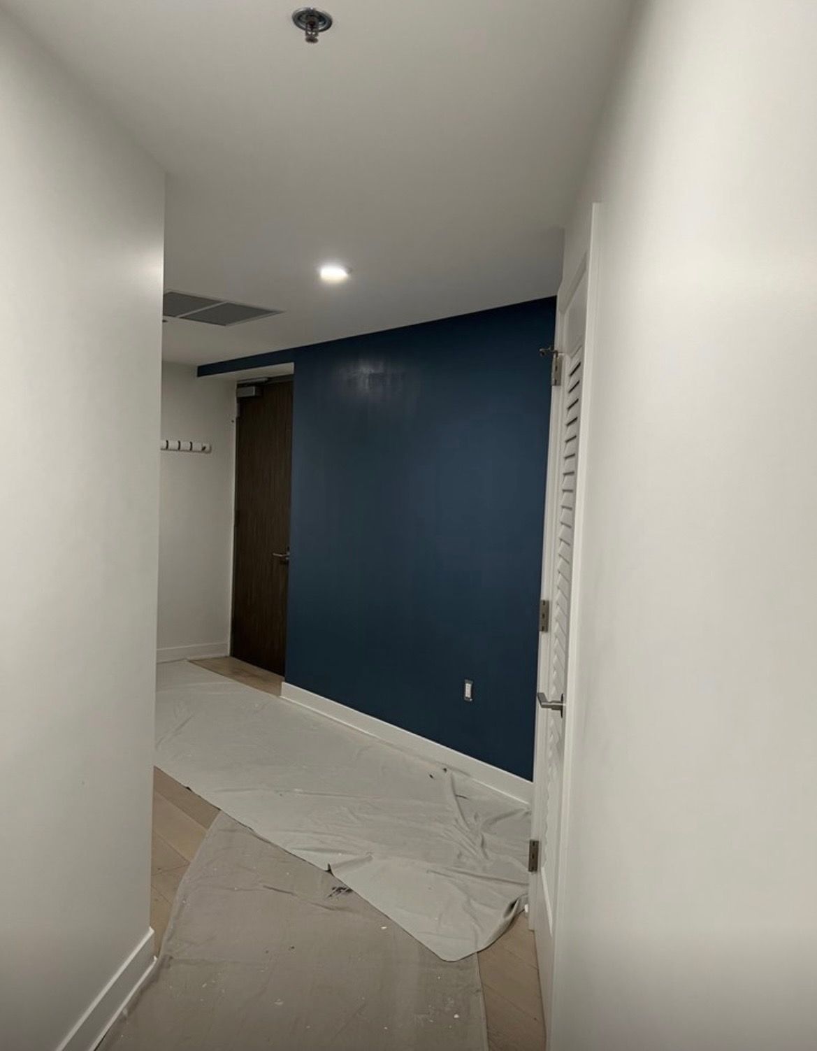 A hallway with a blue wall and white walls.