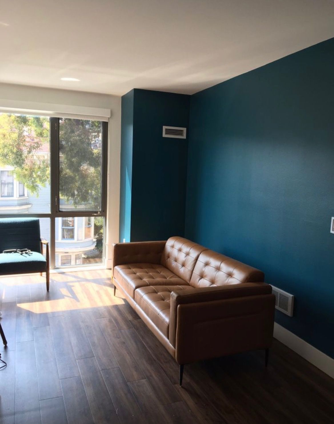 A living room with blue walls and a brown couch