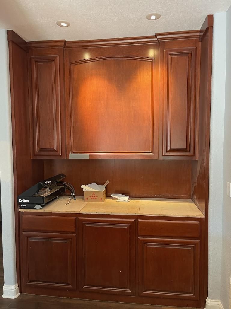 A kitchen with wooden cabinets and a printer on the counter.