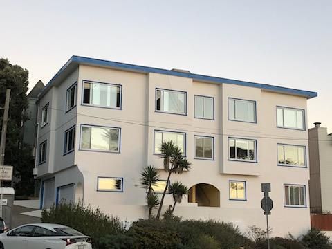 A large white building with a blue roof and a lot of windows.