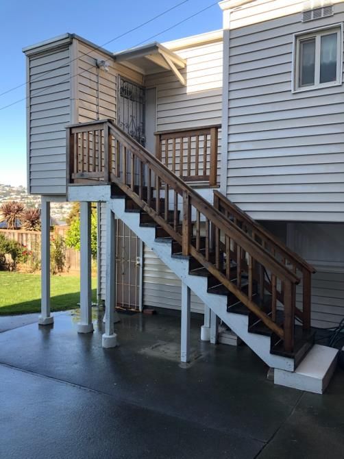 A white house with wooden stairs leading up to it