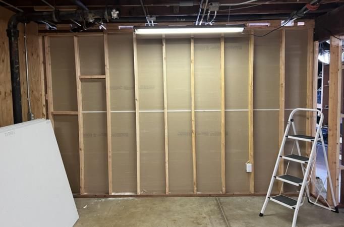 A ladder is sitting next to a wall in a room.