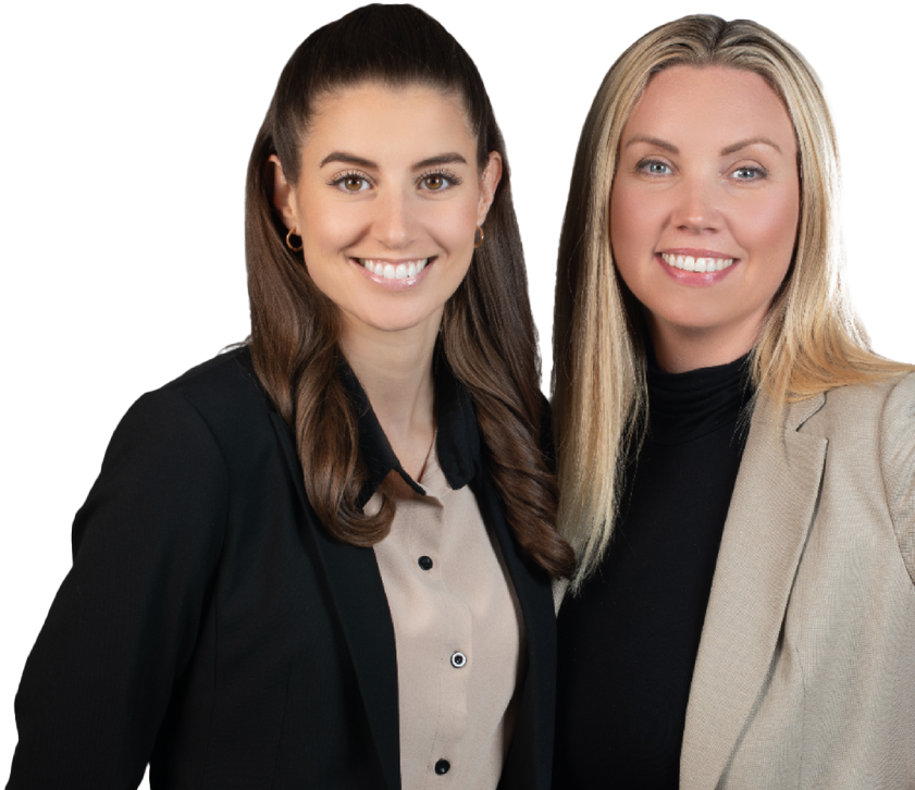 Two smiling women in business attire, posing together.