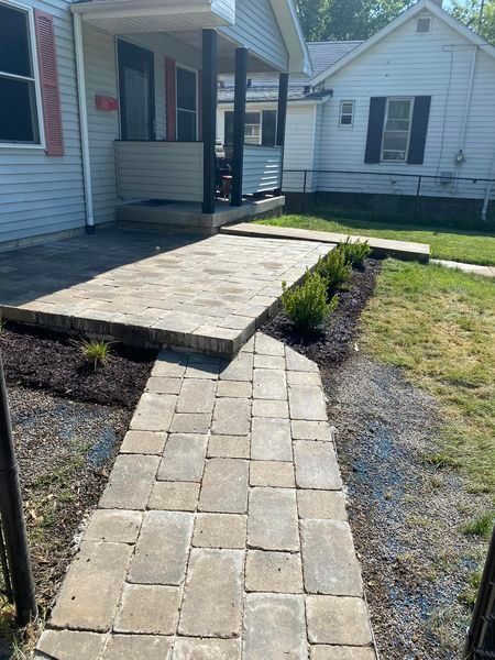 A brick walkway leading to a white house