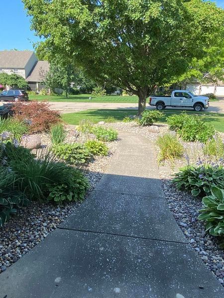 A white truck is parked on the side of the road next to a tree.
