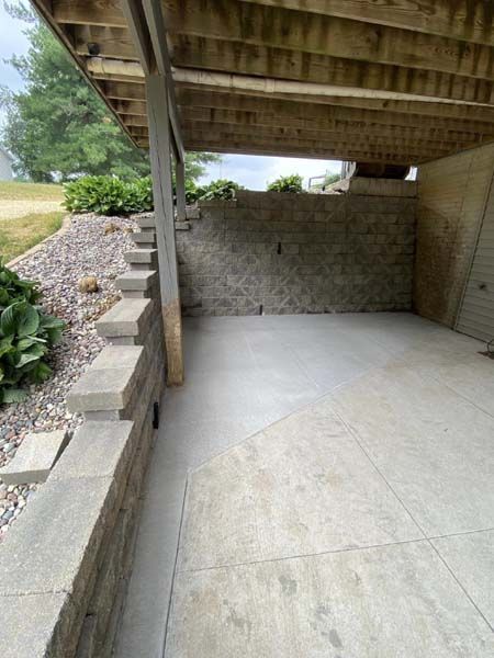 A concrete patio with stairs leading up to it and a wooden roof.