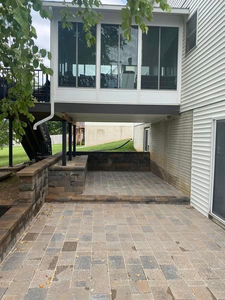 A house with a patio and a deck underneath it.
