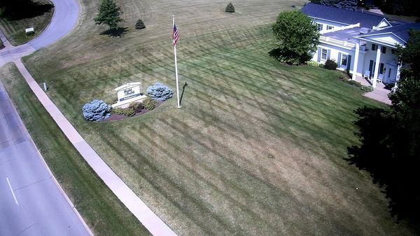 An aerial view of a house with a flag pole in front of it.