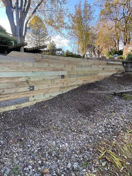 A wooden fence is being built next to a gravel road.
