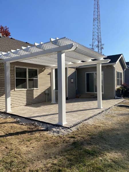 A house with a pergola on the back of it.