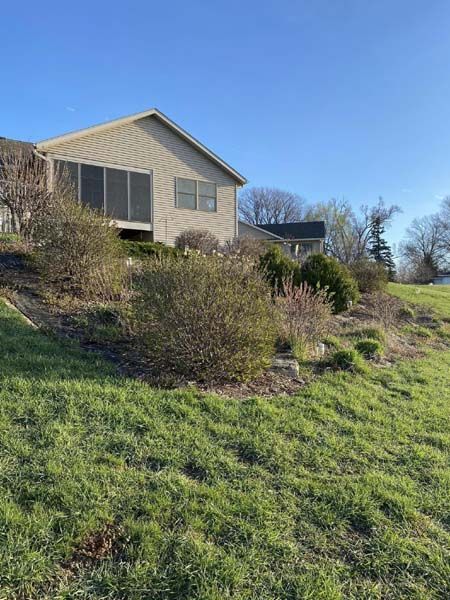 A house is sitting on top of a grassy hill.