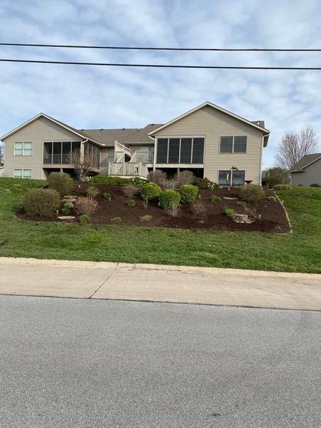 A large house is sitting on top of a grassy hill.