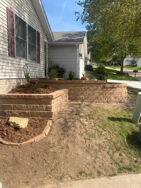 A house with a brick wall in front of it.