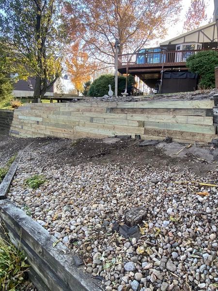 A wooden wall is being built in front of a house.