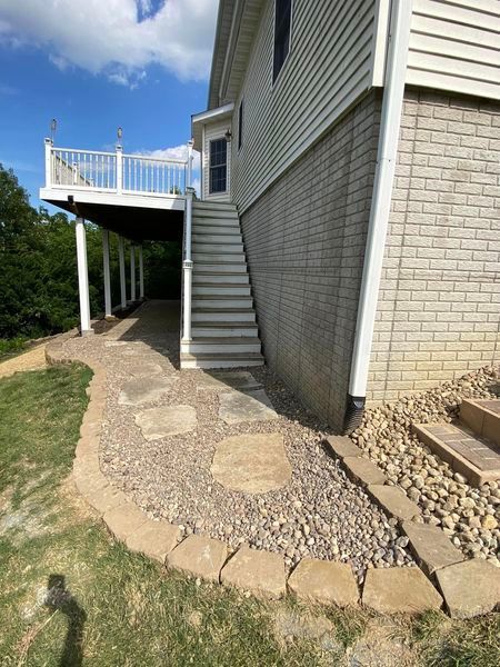 A house with a deck and stairs on the side of it.