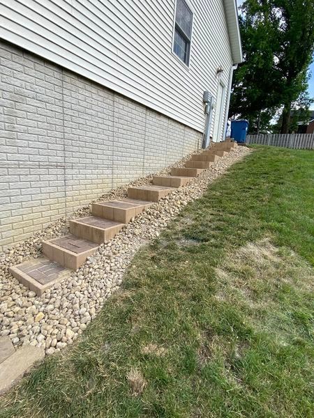 There are stairs leading up to the side of a house.